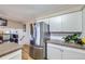 Functional kitchen with a stainless-steel refrigerator, ample cabinet space, and granite countertops at 8210 Hoyt Ct, Arvada, CO 80005