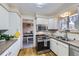 Well-lit kitchen with modern stainless-steel appliances, light cabinetry, and a functional layout at 8210 Hoyt Ct, Arvada, CO 80005