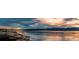 Scenic lake view at sunset with rocks in the foreground and mountains in the distance at 8210 Hoyt Ct, Arvada, CO 80005