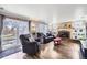 Inviting living room with a brick fireplace, built-in shelving, and sliding glass doors to the backyard at 8210 Hoyt Ct, Arvada, CO 80005