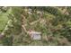 Aerial view of a house surrounded by dense green trees and a winding dirt road at 2545 N State Highway 67, Sedalia, CO 80135