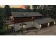 Stunning aerial view of a rustic home with an attached garage and lush forest backdrop at dusk at 2545 N State Highway 67, Sedalia, CO 80135