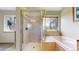 Bathroom featuring a glass enclosed shower, and a soaking tub with a large window with outdoor views at 2545 N State Highway 67, Sedalia, CO 80135