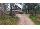 Rustic home features a dirt driveway leading to a detached garage and lush forest surrounds at 2545 N State Highway 67, Sedalia, CO 80135