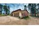 Three car garage featuring custom doors and landscaping in a tranquil forested location at 2545 N State Highway 67, Sedalia, CO 80135