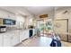Bright kitchen featuring white cabinetry, tile backsplash, stainless steel appliances, and sliding door to outside at 2545 N State Highway 67, Sedalia, CO 80135