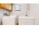 Clean laundry area with washer and dryer, featuring a cabinet and small window at 2545 N State Highway 67, Sedalia, CO 80135