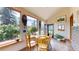 Bright sun room with large picture windows offering views of the wooded exterior at 2545 N State Highway 67, Sedalia, CO 80135