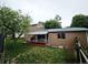 Backyard view with a two story home, a red wooden deck with a grill, and green grass and mature trees at 4677 S Salida St, Aurora, CO 80015