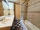 Bathroom featuring a tub-shower combo, a sink with a large mirror, and black and white checkered flooring at 4677 S Salida St, Aurora, CO 80015