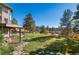 Manicured backyard features a stone walkway and mature trees at 8544 Burning Tree Trl, Franktown, CO 80116
