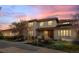Stunning two-story home featuring a tiled roof, landscaped yard, and inviting covered front porch at sunset at 8544 Burning Tree Trl, Franktown, CO 80116