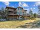 Backyard of the two-story home featuring large decks and stone retaining wall at 8544 Burning Tree Trl, Franktown, CO 80116