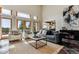Bright living room boasts large windows, a cozy seating arrangement, and views of the landscape at 8544 Burning Tree Trl, Franktown, CO 80116