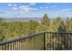 Scenic view from the balcony, featuring lush green trees and majestic mountains in the distance at 8544 Burning Tree Trl, Franktown, CO 80116
