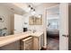 Bathroom featuring a single sink vanity, large mirror, and open doorway view into the bedroom at 8391 W 90Th Pl # 101, Westminster, CO 80021