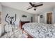 Bedroom with neutral walls, a ceiling fan, an elliptical, and a large bed with floral bedding at 8391 W 90Th Pl # 101, Westminster, CO 80021
