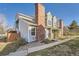 View of the townhome showing walkway, brick chimney, gray siding, and fenced-in yard at 8391 W 90Th Pl # 101, Westminster, CO 80021