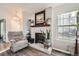 Cozy fireplace with white brick surround, wooden mantle, and lots of natural light at 8391 W 90Th Pl # 101, Westminster, CO 80021