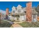Charming townhome with gray siding, brick chimney, manicured lawn, and inviting front entrance at 8391 W 90Th Pl # 101, Westminster, CO 80021