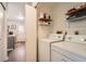 Efficient laundry room with white washer and dryer, storage shelves, and access to kitchen at 8391 W 90Th Pl # 101, Westminster, CO 80021