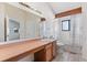 Bathroom featuring a large mirror, sink, toilet, and shower/tub combination with a window at 10470 W 83Rd Ave, Arvada, CO 80005