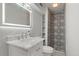 Stylish bathroom showcases a tiled walk-in shower and a vanity with a marble countertop and sink at 10470 W 83Rd Ave, Arvada, CO 80005