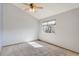 Bright bedroom features neutral carpet and walls, a ceiling fan, and a window with natural light at 10470 W 83Rd Ave, Arvada, CO 80005