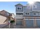 Inviting blue home featuring an attached garage and a charming second-story balcony at 10470 W 83Rd Ave, Arvada, CO 80005