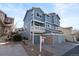 Three-story blue home featuring an attached garage and a charming second-story balcony at 10470 W 83Rd Ave, Arvada, CO 80005