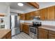 Kitchen featuring stainless steel appliances, white countertops, and light wood cabinets at 10470 W 83Rd Ave, Arvada, CO 80005