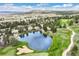 Aerial view of houses backing to golf course and lake with mountain views at 3216 Country Club Pkwy, Castle Rock, CO 80108