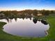 Stunning sunset aerial view of the houses surrounding the neighborhood pond surrounded by nature and lush greenery at 3216 Country Club Pkwy, Castle Rock, CO 80108