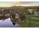 Aerial view of a beautiful house on the water with lush trees, gorgeous mountain views, and a nearby golf course at 3216 Country Club Pkwy, Castle Rock, CO 80108