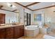 Bright bathroom featuring a soaking tub under a picture window and a separate glass-enclosed shower at 3216 Country Club Pkwy, Castle Rock, CO 80108