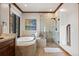 Bright bathroom featuring a soaking tub under a picture window and a separate glass-enclosed shower at 3216 Country Club Pkwy, Castle Rock, CO 80108