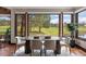 Bright dining room features large windows overlooking the lush green golf course and decorative oval wooden table at 3216 Country Club Pkwy, Castle Rock, CO 80108