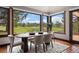 Bright dining room features views of the lush green golf course and a modern decorative oval wooden table at 3216 Country Club Pkwy, Castle Rock, CO 80108