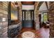 Grand foyer with stone archways, hardwood floors, mosaic rug, and a gorgeous black door with glass panels at 3216 Country Club Pkwy, Castle Rock, CO 80108