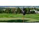 Scenic golf course view with a well-manicured green and country club flag amidst lush trees at 3216 Country Club Pkwy, Castle Rock, CO 80108