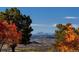 Expansive landscape view with rolling hills, fall foliage, and a charming town nestled in the valley at 3216 Country Club Pkwy, Castle Rock, CO 80108