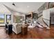 Open-concept living room featuring hardwood floors, a stone fireplace, and a staircase to the second floor at 3216 Country Club Pkwy, Castle Rock, CO 80108