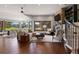 Open-concept living room featuring hardwood floors, a stone fireplace, and open views of the dining room at 3216 Country Club Pkwy, Castle Rock, CO 80108