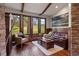 Cozy living room with hardwood floors, stone accent wall, beam ceilings, and scenic outdoor views at 3216 Country Club Pkwy, Castle Rock, CO 80108