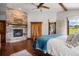 Comfortable main bedroom featuring a stone fireplace, wood floors, and a door leading to the outside patio at 3216 Country Club Pkwy, Castle Rock, CO 80108