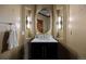 Elegant powder room featuring stylish vanity and lighting, a decorative oval mirror, and textured walls at 3216 Country Club Pkwy, Castle Rock, CO 80108