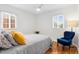 Bright bedroom with hardwood floors, a queen bed, and a cozy blue chair at 3739 W 46Th Ave, Denver, CO 80211
