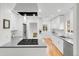 Modern kitchen featuring white cabinets, stainless steel appliances, quartz countertops, and hardwood floors at 3739 W 46Th Ave, Denver, CO 80211
