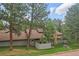 Charming exterior view of the home showcasing natural landscaping and stone chimney at 2378 Hearth Dr # 20, Evergreen, CO 80439