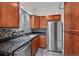Updated kitchen featuring stone countertops, stainless steel appliances, and warm wood cabinetry at 2378 Hearth Dr # 20, Evergreen, CO 80439